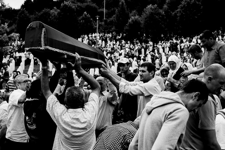 Muslim Bosnians carrying coffins of newly identified victims of genocide to the graves at the Srebrenica Potočari Memorial.